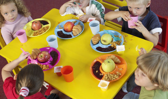 kids sitting around a yellow table eating