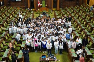 Members and students of The Children’s Breakfast Club in Ottawa at the parliament with the Canadian President Justin Trudeau. Everyone is looking into the camera, smiling. 