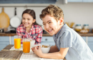 Two kids happily having healthy breakfast