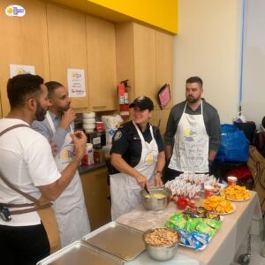 A team of the children's breakfast club volunteers come together to prepare meals in a school facility.